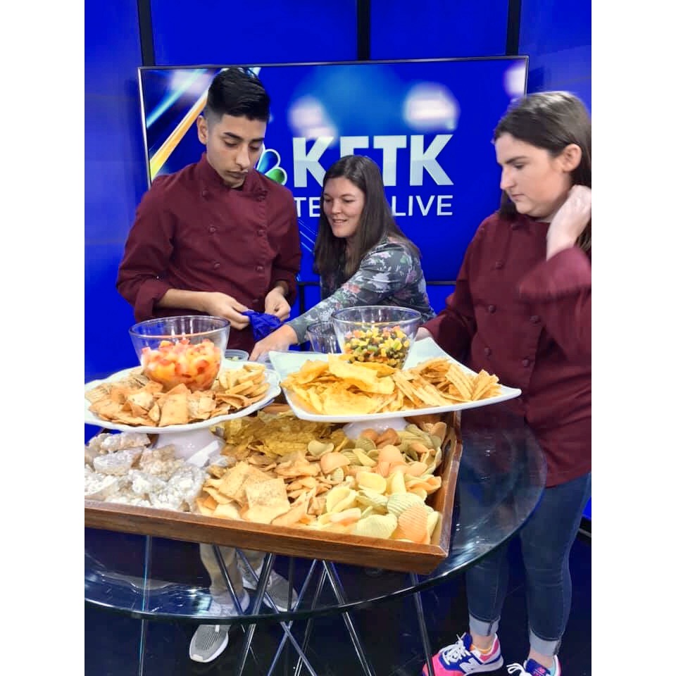 Palestine ISD students and their teacher prepare tray full of various chips and dips for a News segment.